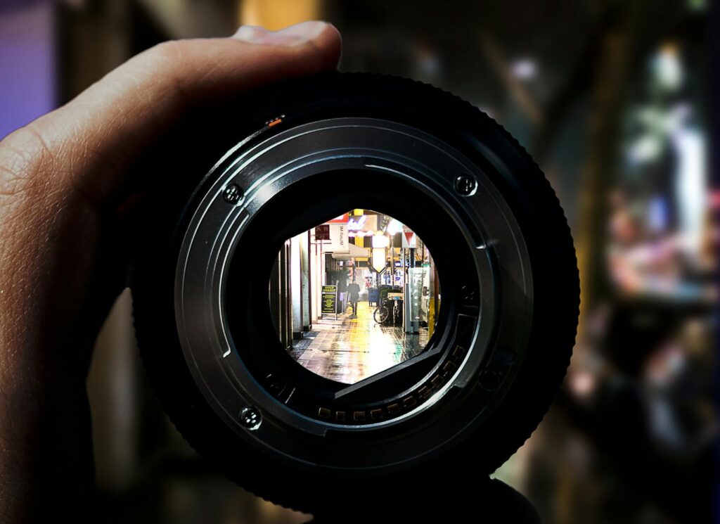 Person Holding Black Camera Lens